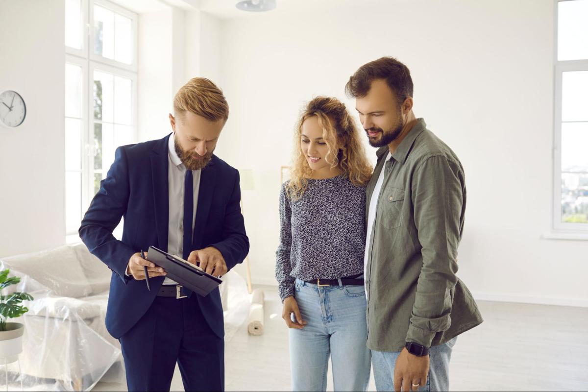 Professionele expert toont een plaatsbeschrijving op tablet aan huurder en verhuurder in een woning